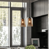Two glass pendants hung by a window in a dark kitchen