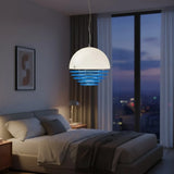 Ring-shade pendant seen against a plain wall with a warm glow