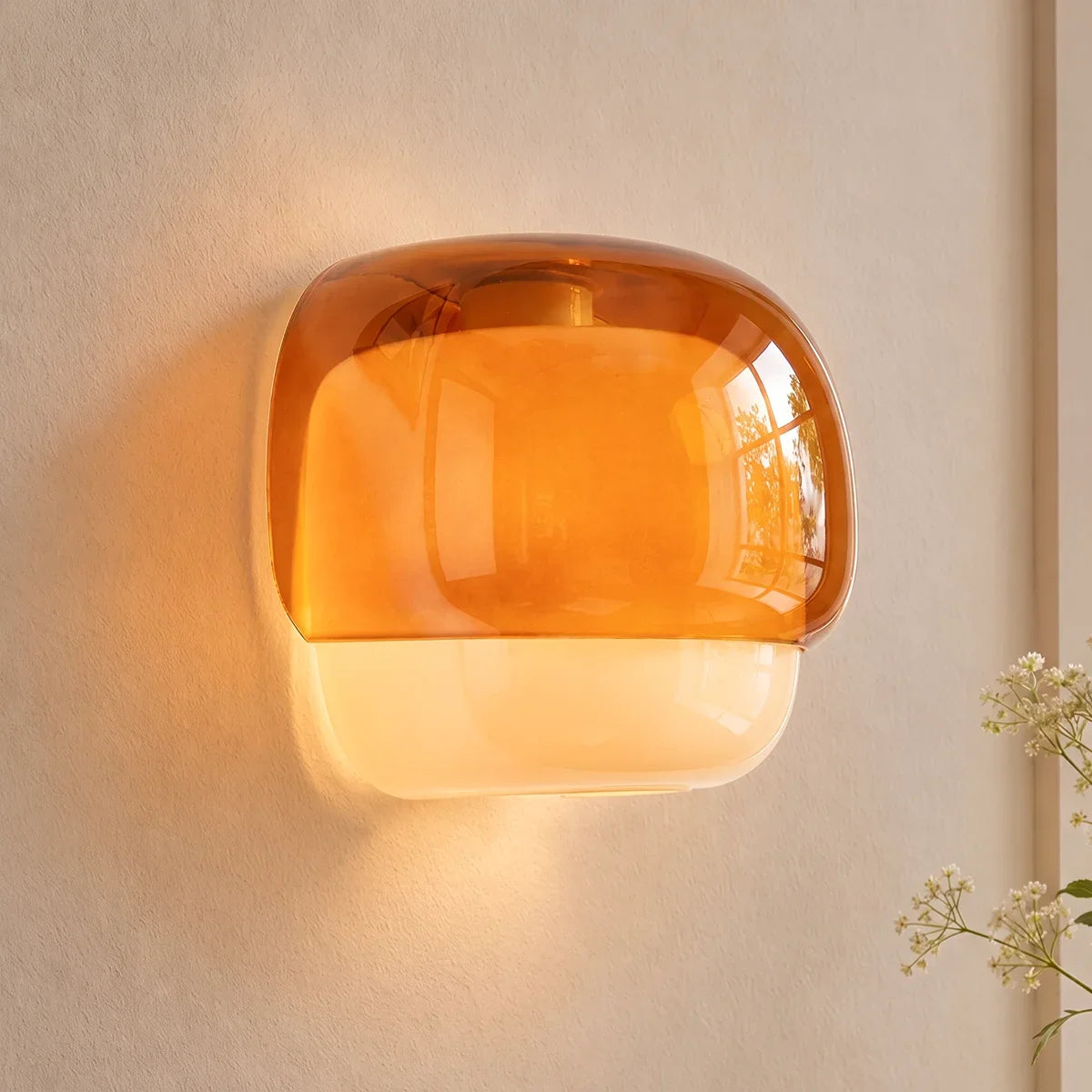 Rounded amber glass sconce with opal lower band on plain background