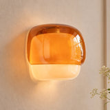 Rounded amber glass sconce with opal lower band on plain background