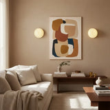 Pair of glass wall sconces flanking abstract art in neutral lounge
