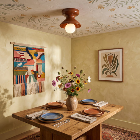 Rust glazed ceramic flush mount on a patterned ceiling above a dining table