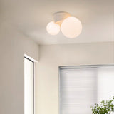 Twin globe ceiling light close to a window corner with a plant below