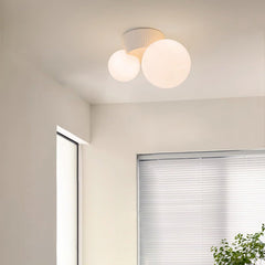 Twin globe ceiling light close to a window corner with a plant below