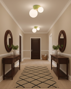 Twin globe ceiling lights above a hallway runner between two round mirrors