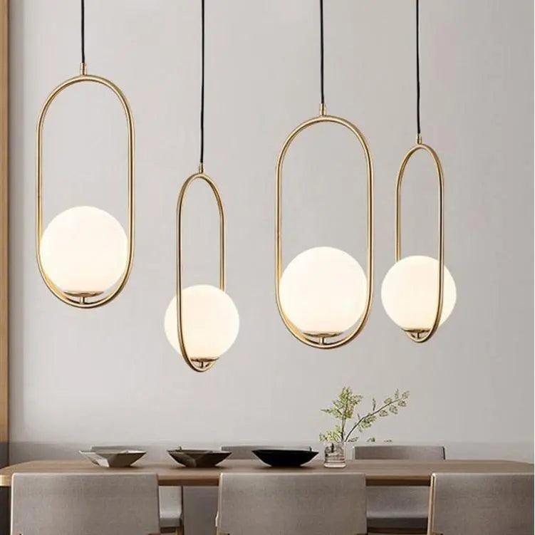 Three gold hoop pendants at staggered heights over a dining table