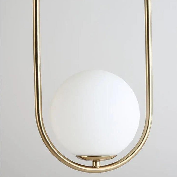 Gold oval hoop pendant seen close with the milk glass globe seated low