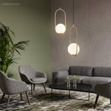 Gold hoop pendants hanging at two heights in a green walled lounge