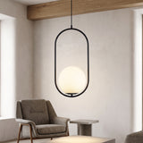 Black oval hoop pendant with a white glass globe above an armchair