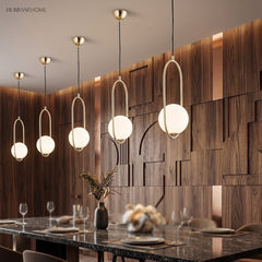 Gold globe pendants in a line above a marble dining table