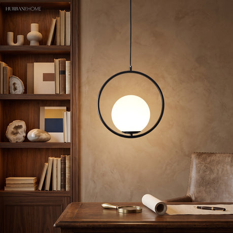 Black round hoop pendant with a glowing globe above a wood desk