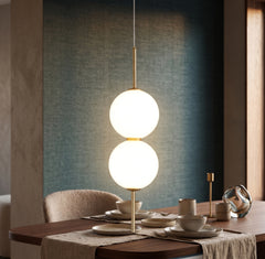 Two opal glass globes on a brass rod above a set dining table