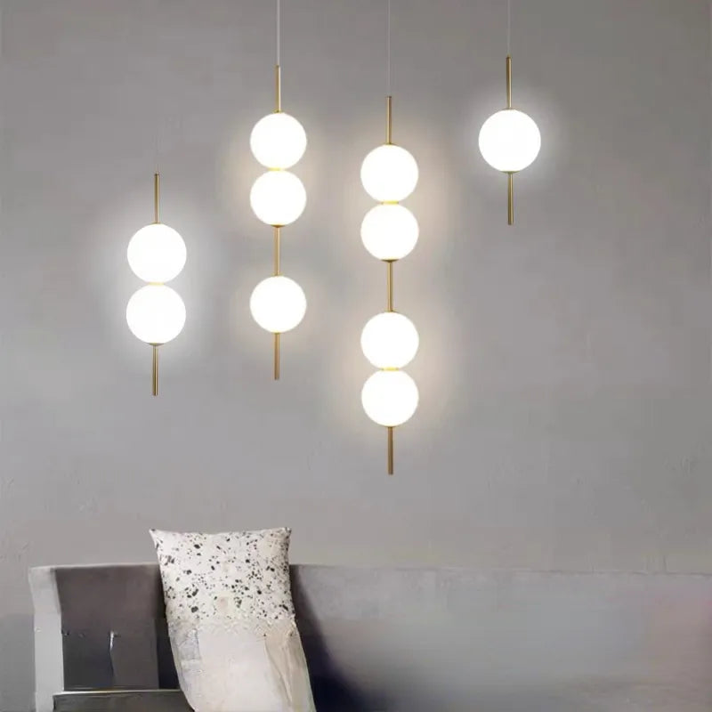 Grouped globe pendants at varied heights above a grey corner sofa