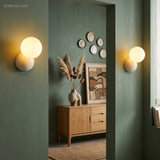 Pair of globe wall sconces either side of a doorway in a dark green hallway