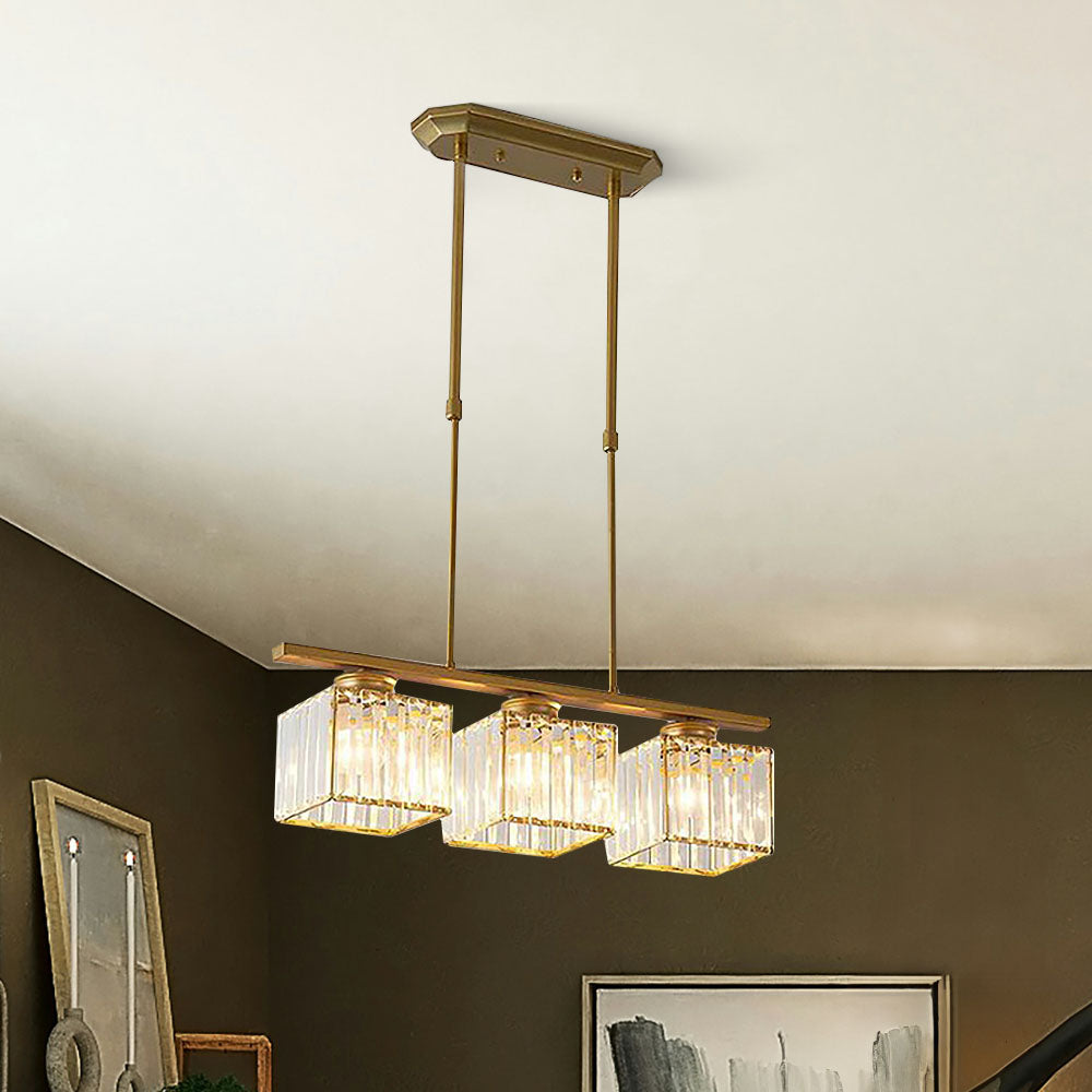 Close view of a gold three light pendant with faceted glass cube shades