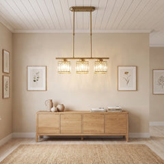 Gold three light linear pendant light above an oak sideboard and framed prints