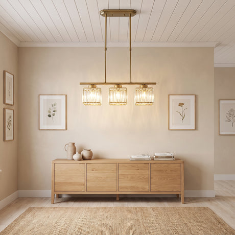 Gold three light linear pendant light above an oak sideboard and framed prints