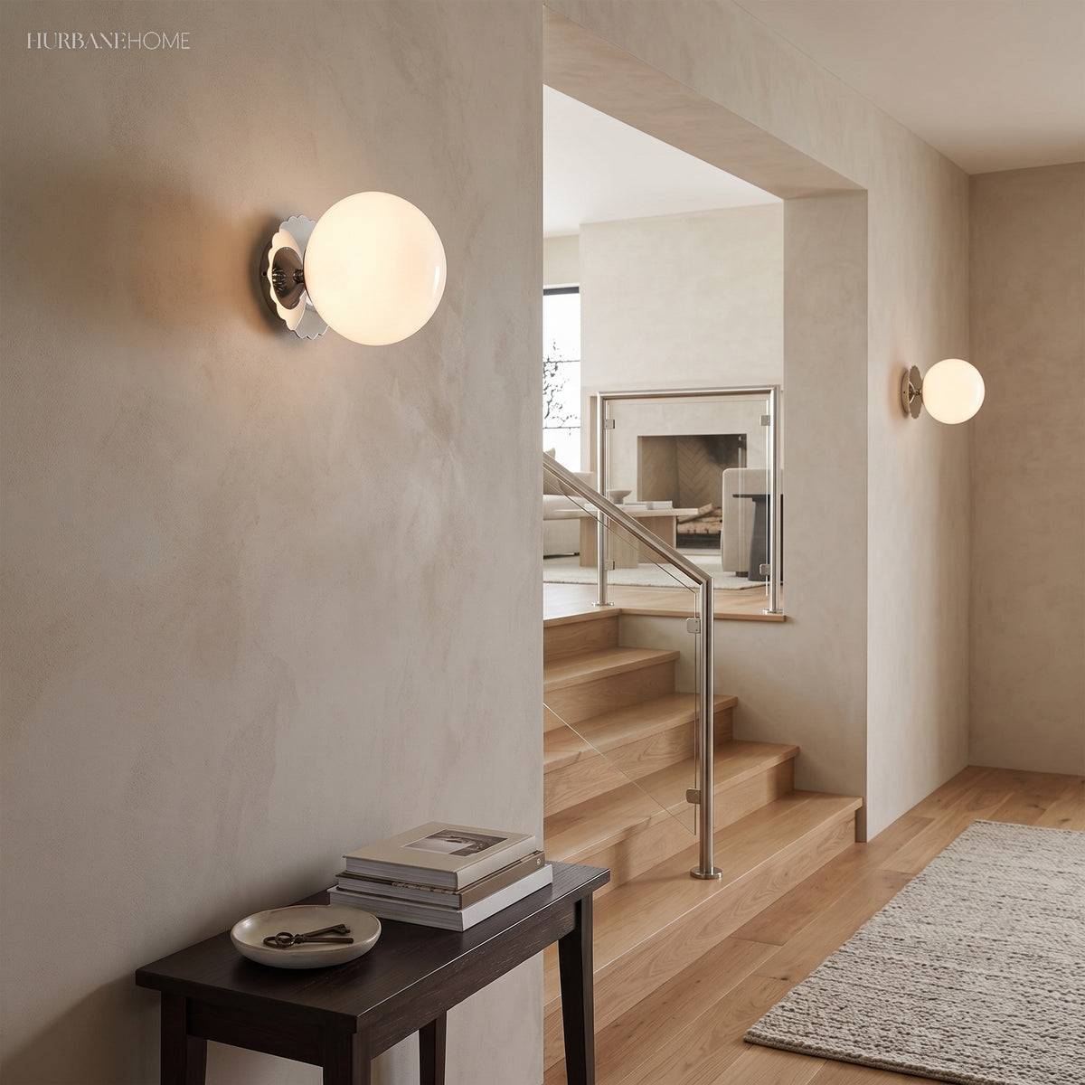 White globe sconce with chrome scalloped plate beside a staircase