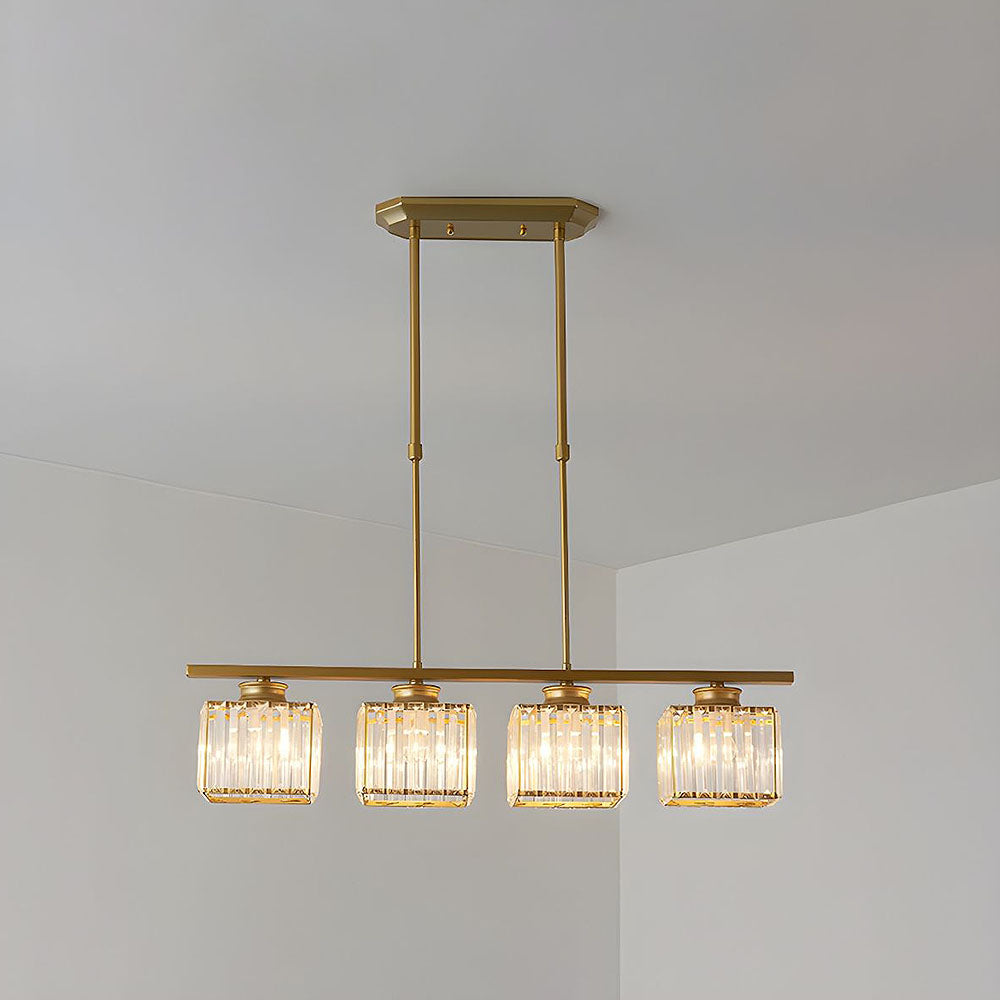 Gold bar chandelier with four faceted glass cube shades against a white wall