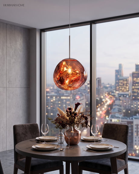 Copper toned pendant above a round dining table set against a night city view