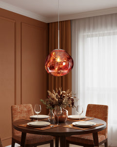 Copper pendant over a round table set for two in a panelled terracotta room