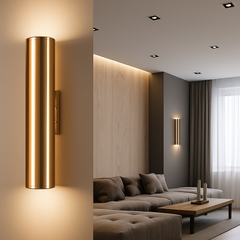 Gold tube sconce lit beside a view of a living room
