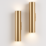 Two gold tube sconces in different lengths lit side by side