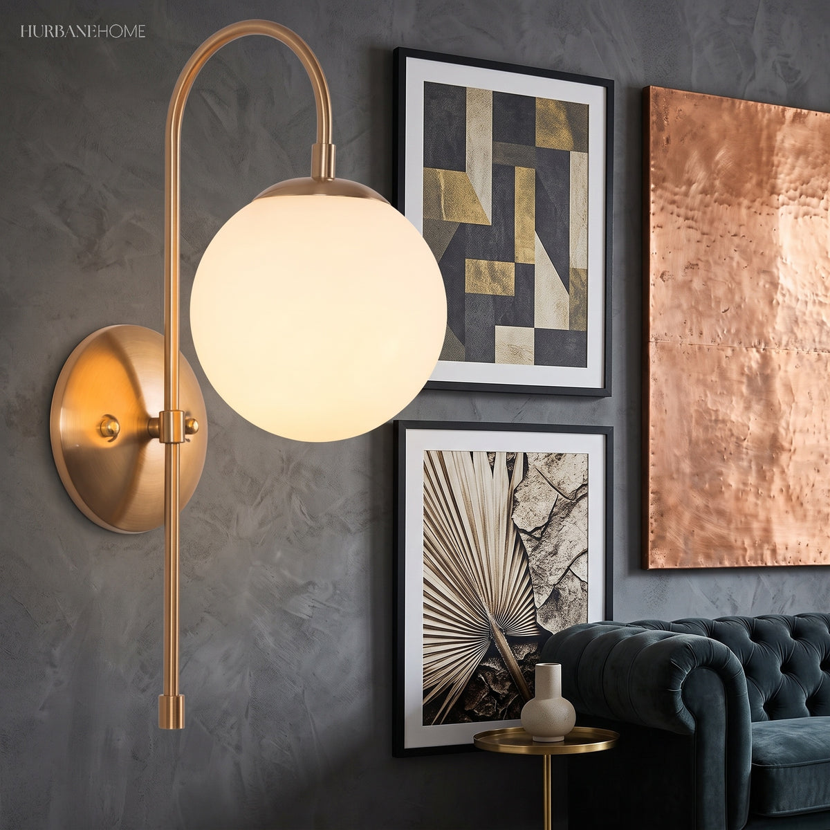 Gold arched sconce with a glowing globe beside framed artwork