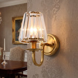 Gold wall sconce lit against damask wallpaper above a dark side table