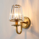 Faceted crystal cone shade glowing warm on a plain pale wall