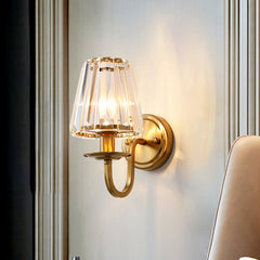 Gold sconce casting warm light across a panelled interior wall