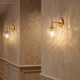 Two rippled globe sconces lit on a herringbone panelled wall