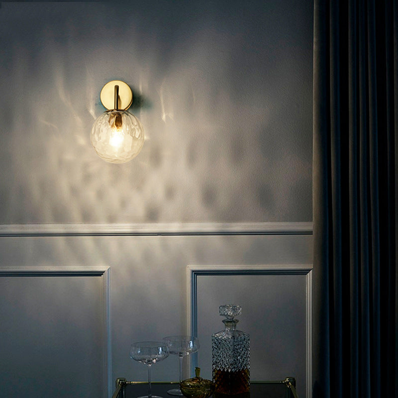 Gold sconce lit above a drinks trolley in a dark panelled room