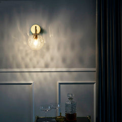 Gold sconce lit above a drinks trolley in a dark panelled room