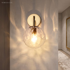Close view of the rippled globe casting dappled light on plaster