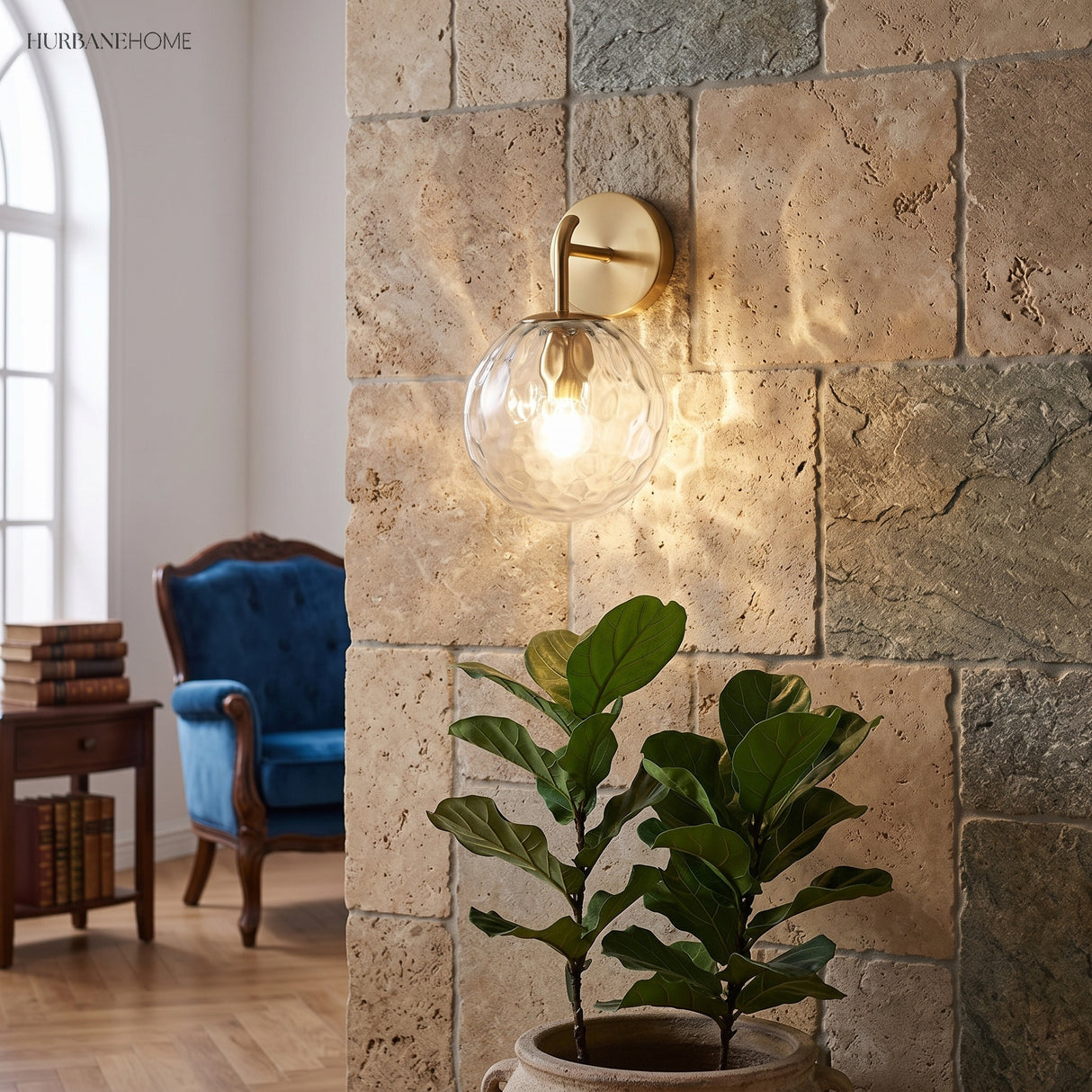 Rippled glass globe sconce lit on a stone wall beside a plant