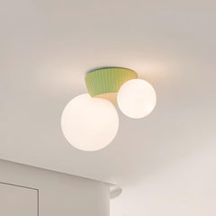 Close view of the green fluted canopy above the two lit opal glass globes