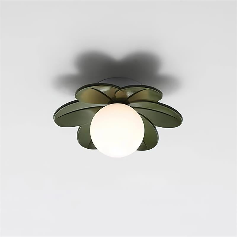 Green petal ceiling light lit against a plain wall, showing the white glass globe