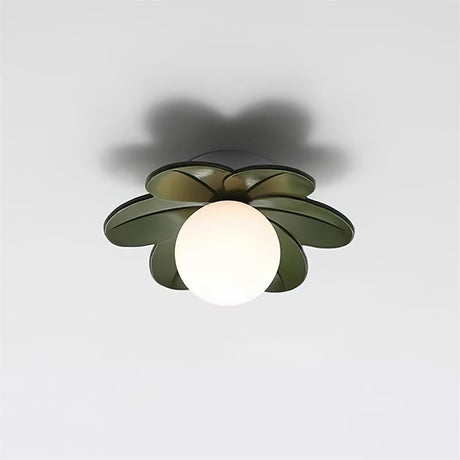 Green petal ceiling light lit against a plain wall, showing the white glass globe
