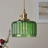 Green fluted glass cylinder pendant light with a brass lamp holder