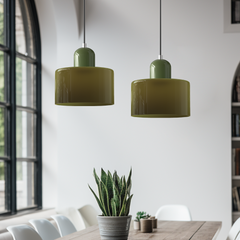 Two green glass pendant lights in a dining room with tall arched windows