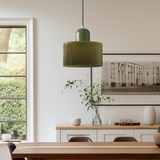 Single green glass pendant light above a wooden dining room sideboard