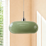 Green oval glass pendant light with chrome cap by a window