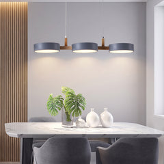 Three matching grey drum shades casting warm pools onto a marble dining table