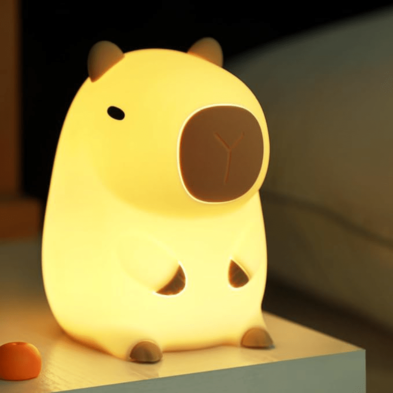 Guinea pig silicone night light with a warm glow on a bedside surface