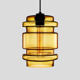 Amber ribbed glass pendant with stacked rings, lit against grey