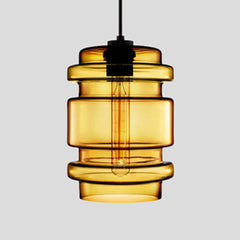 Amber ribbed glass pendant with stacked rings, lit against grey