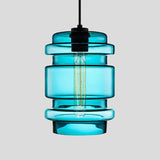 Blue ribbed glass pendant with stacked rings and a filament bulb