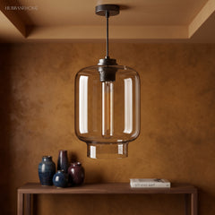 Clear ribbed glass pendant lit above a console in a brown room