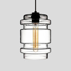 Clear ribbed glass pendant with stacked rings, lit against grey